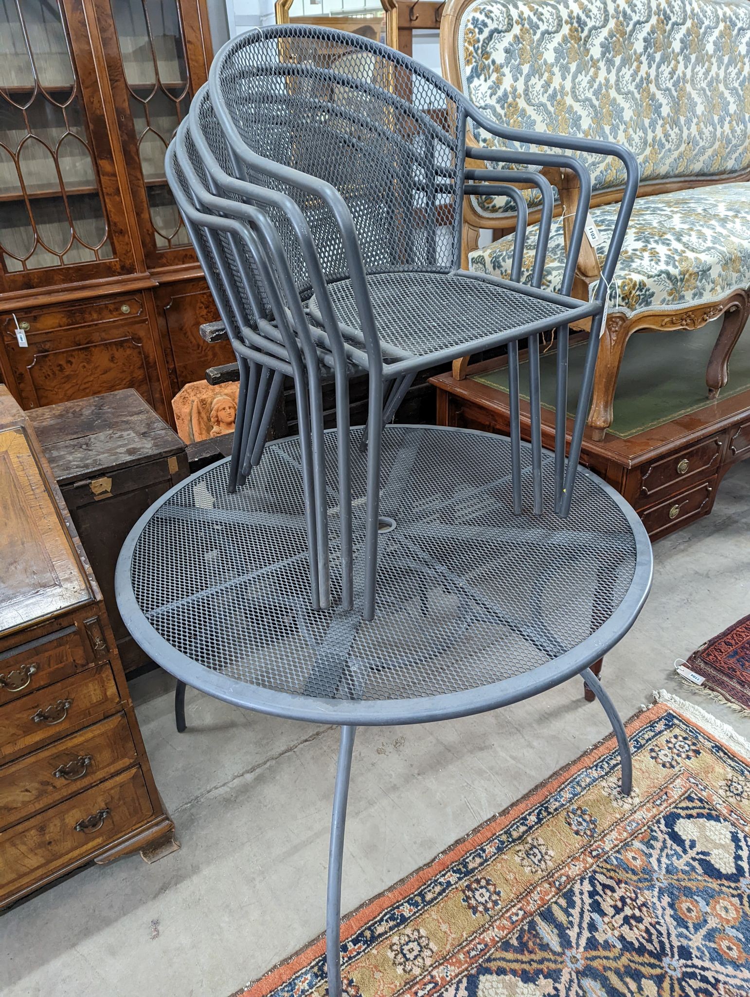 A painted and aluminium wirework circular garden table, diameter 110cm and four chairs